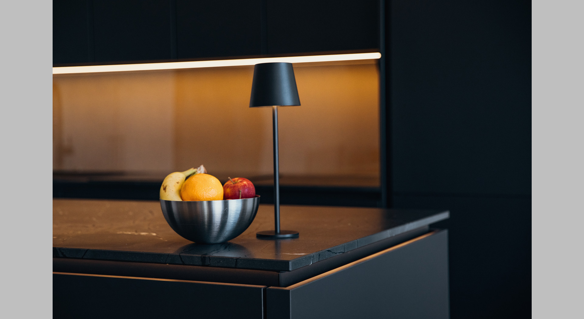 Obstschüssel, Tischlampe auf Kücheninsel mit Marmorarbeitsplatte und indirekter ambienter Beleuchtung