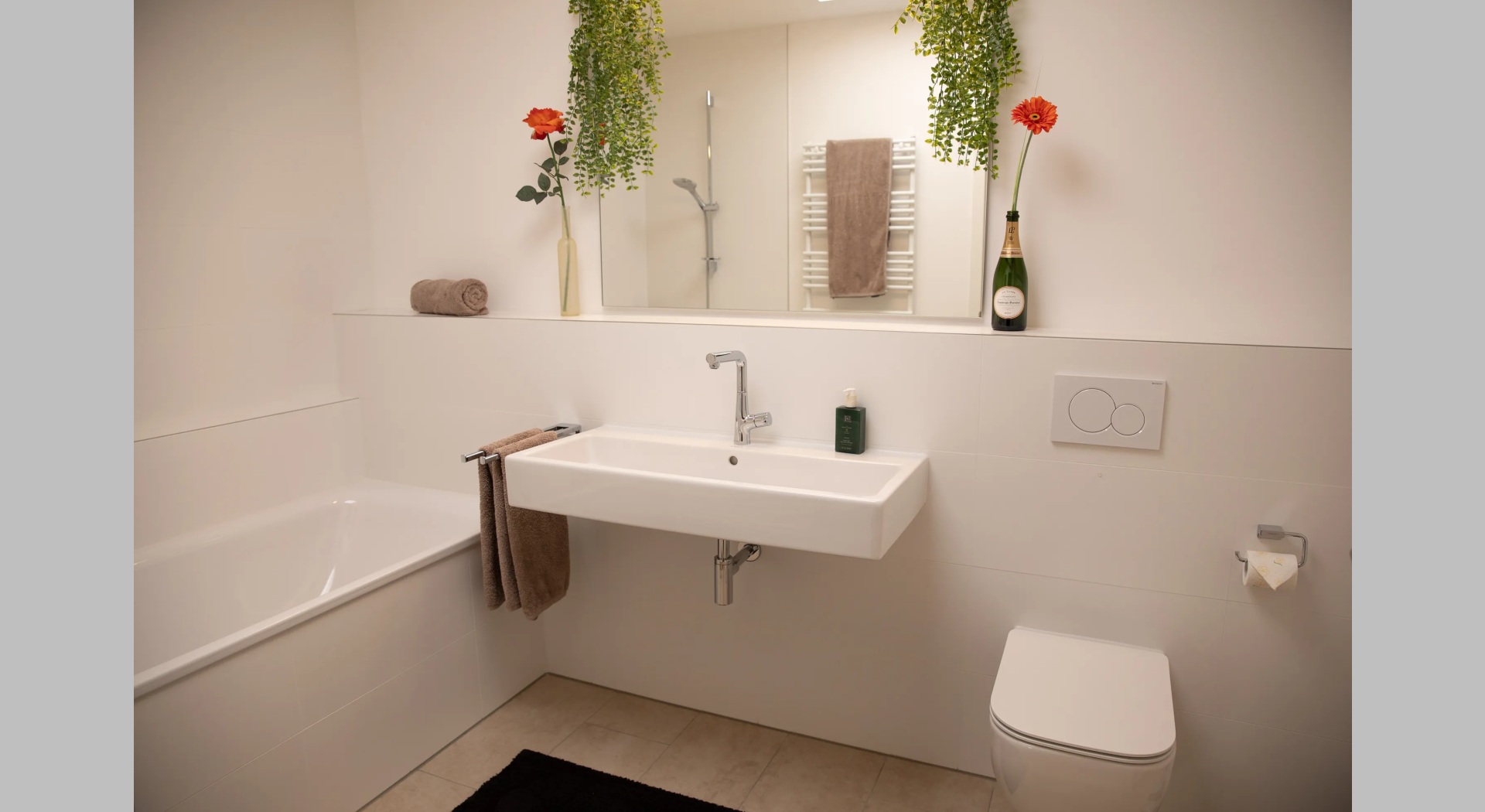 Großes Bad mit Waschbecken, Badewanne und Spiegel