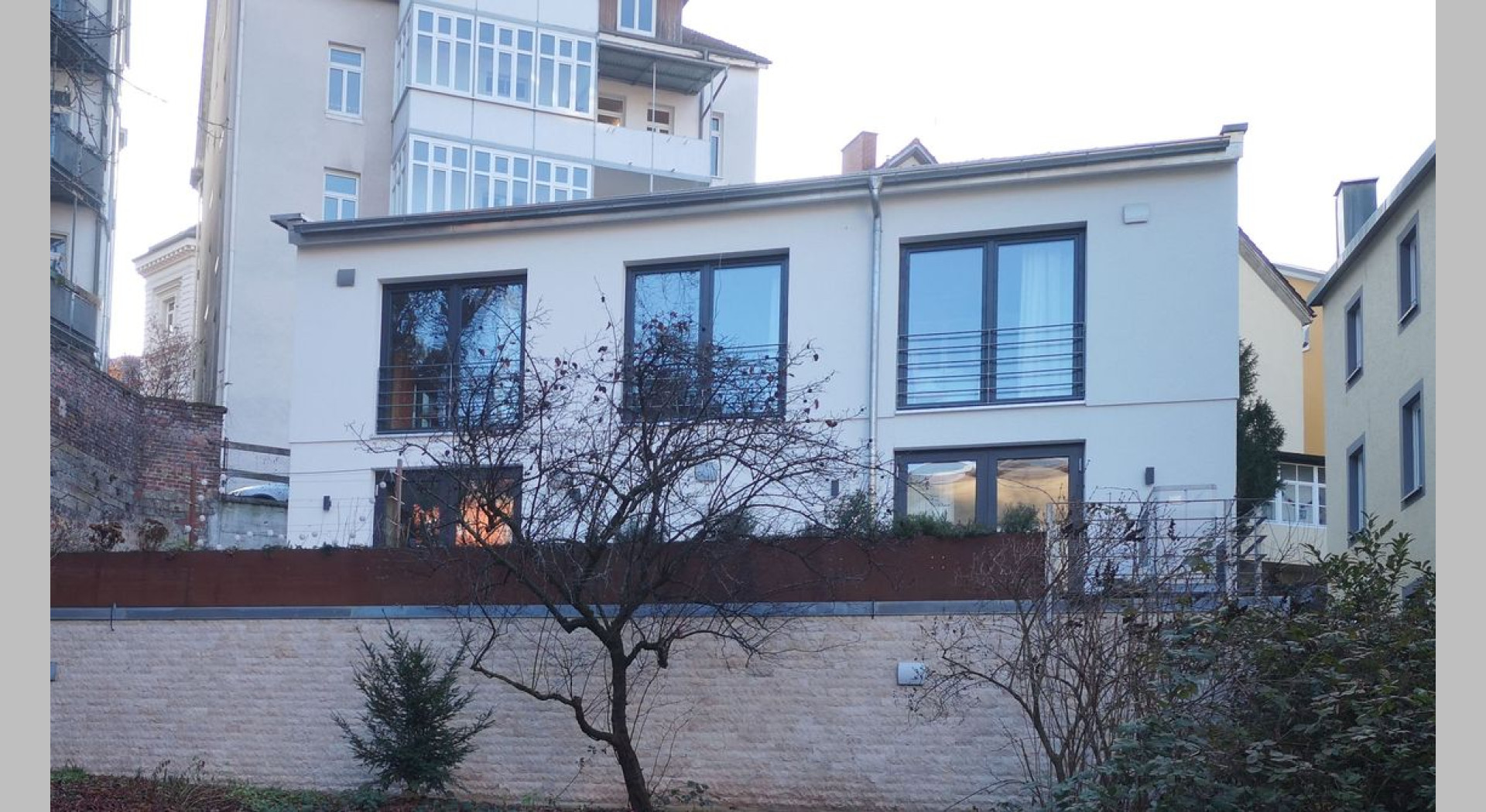 Das Haus ist umgeben von mehrgeschossigen alten Wohnhäusern