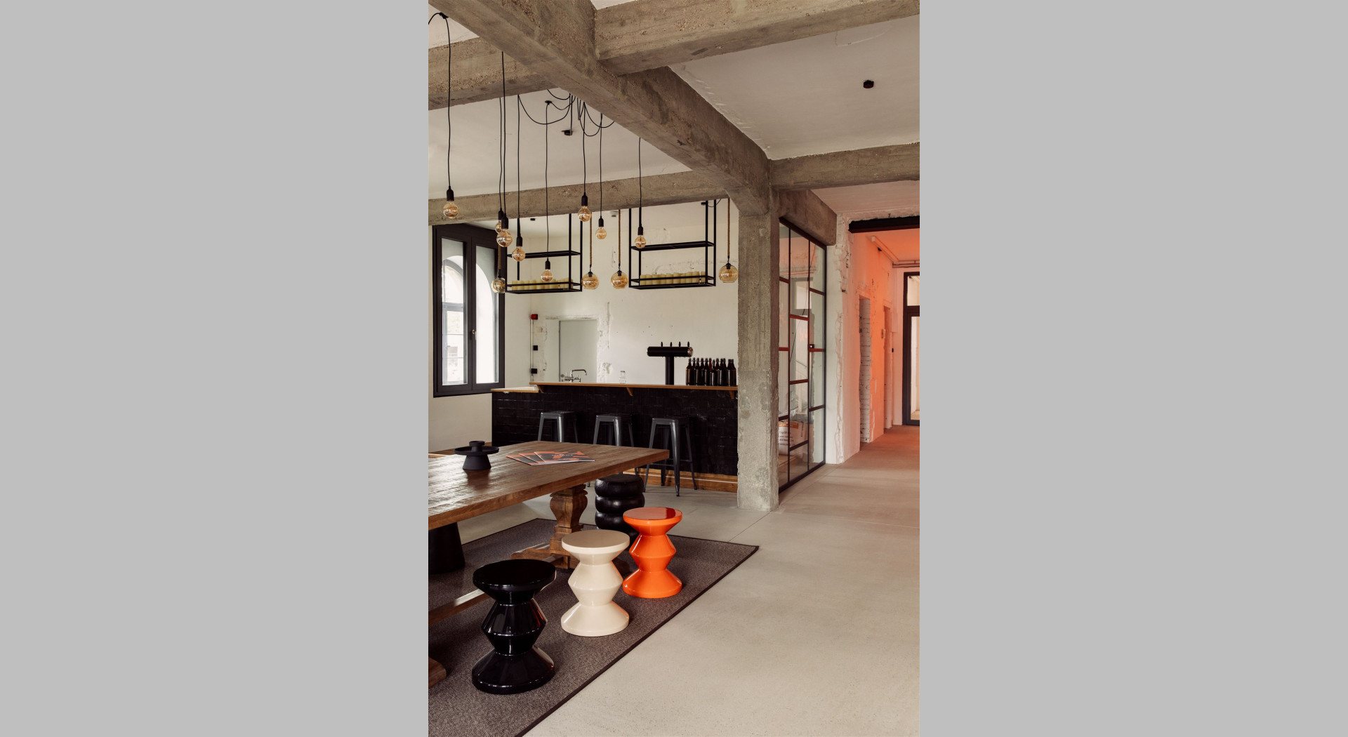 Theke mit Zapfanlage und langem Holztisch mit Hockern