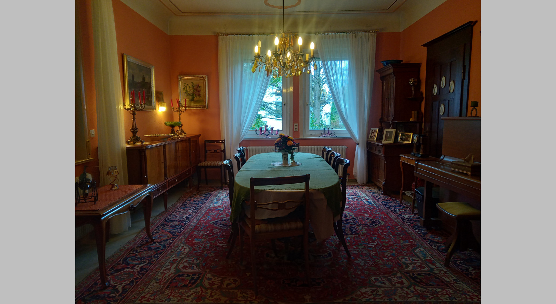 Blick ins Esszimmer mit Kronleuchter und großem Deckenstuck sowie Esstischgarnitur
