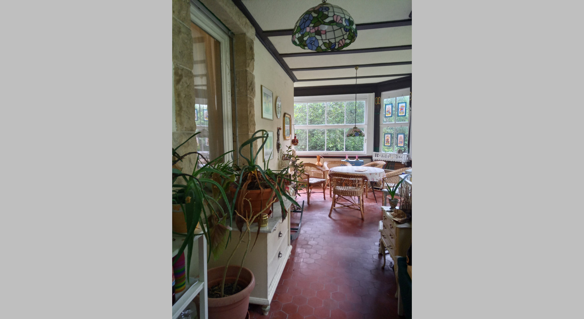 Blick in den Wintergarten auf die linke Sitzecke - rechte Sitzecke spiegelbildlich. Zu sehen ist die durchgängige Glasfront.