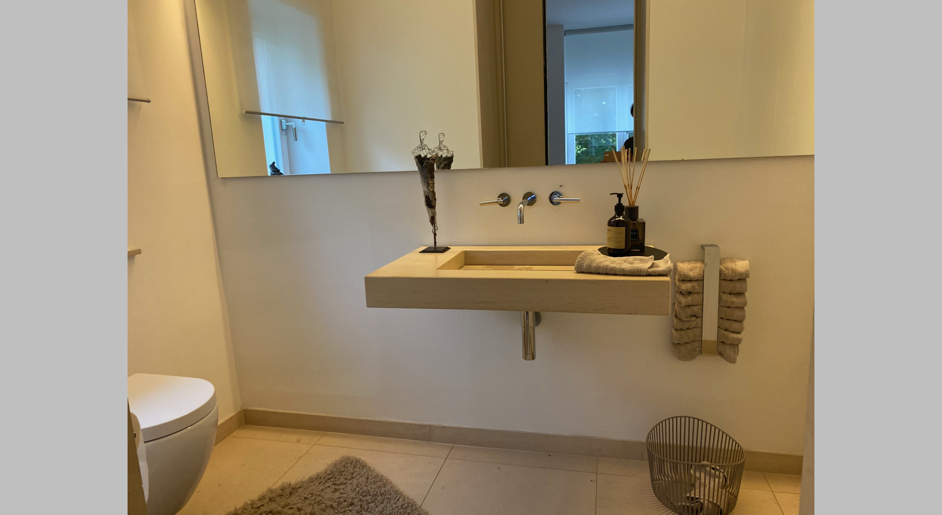 Gäste WC mit Waschbecken aus Sandstein, Wandfüllendem Spiegel und Putzschrank