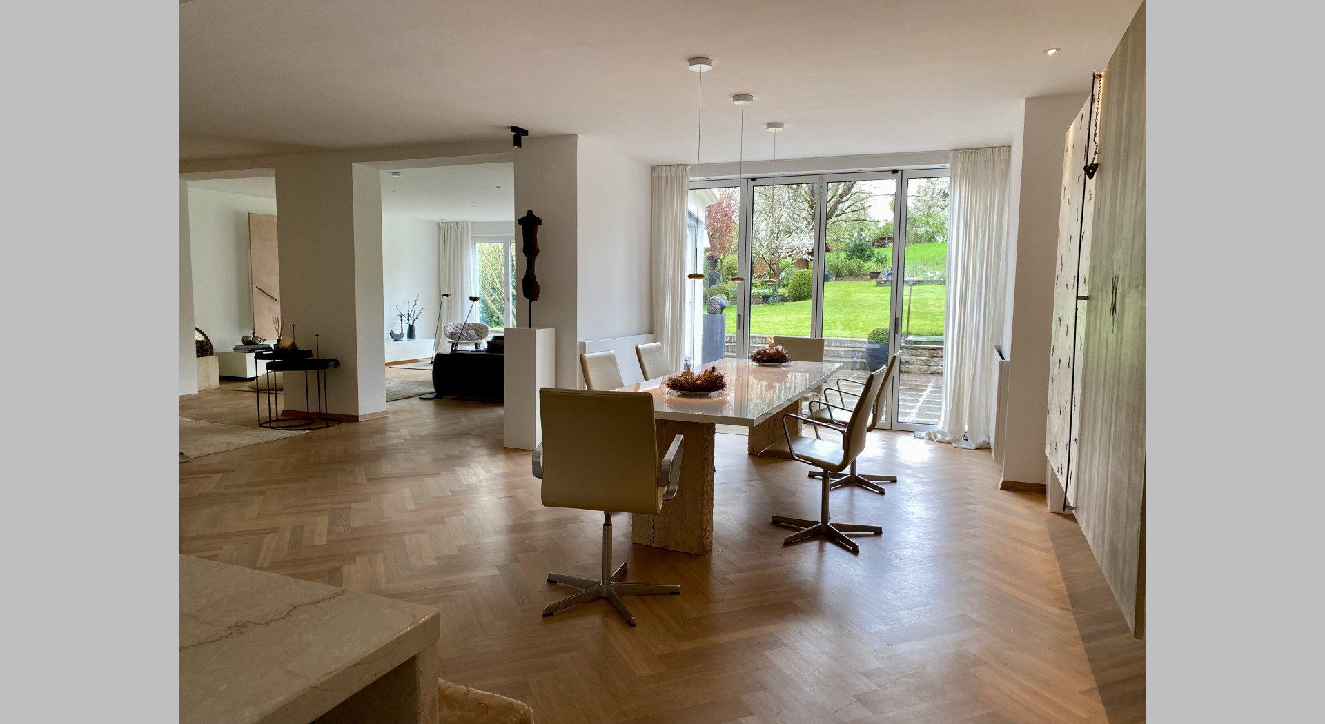 Esstisch und Blick in Garten und angrenzendes Wohnzimmer