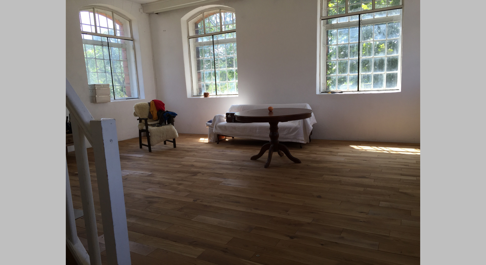 Atelierraum hohe Decken und Fenster Holzboden grosser Raum