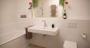 Großes Bad mit Waschbecken, Badewanne und Spiegel