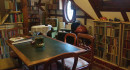 Blick auf die linke Seite der Bibliothek im 2. OG mit Spieltisch und Bücherregalen